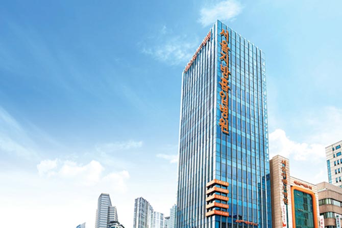 365MC Clinic's tall glass building in South Korea, representing the clinic's expertise in weight management and liposuction